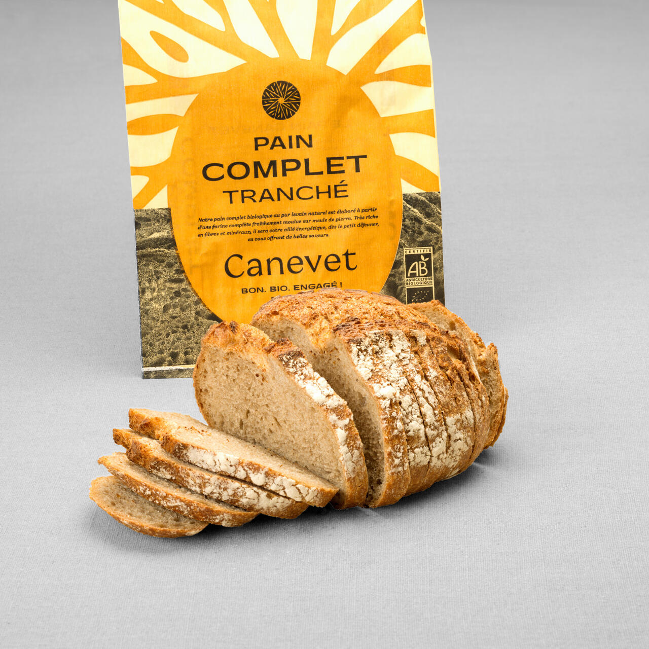 Pain complet au pur levain naturel tranché avec packaging en arrière plan