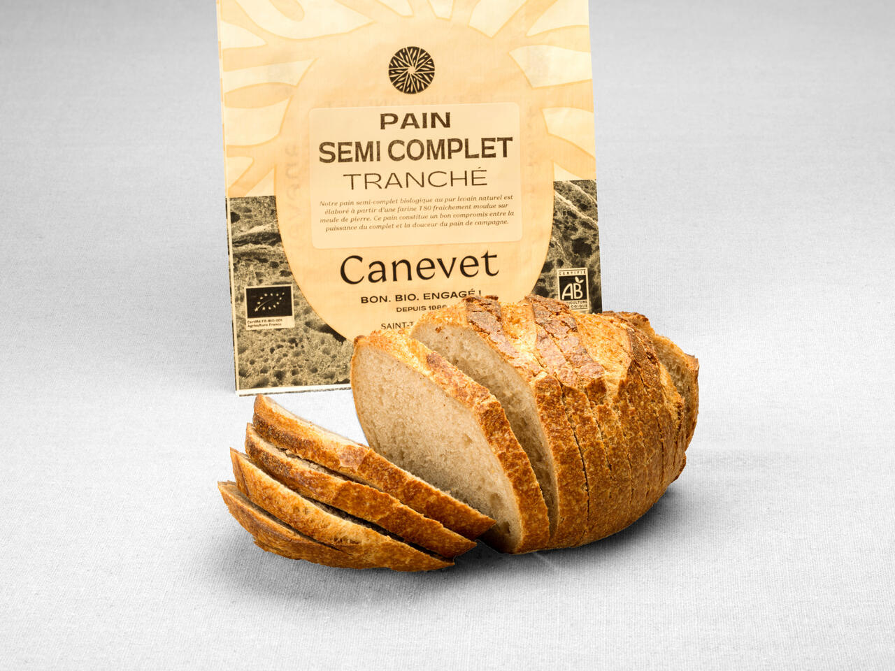 Pain semi complet non moulé au pur levain naturel tranché avec packaging en arrière plan