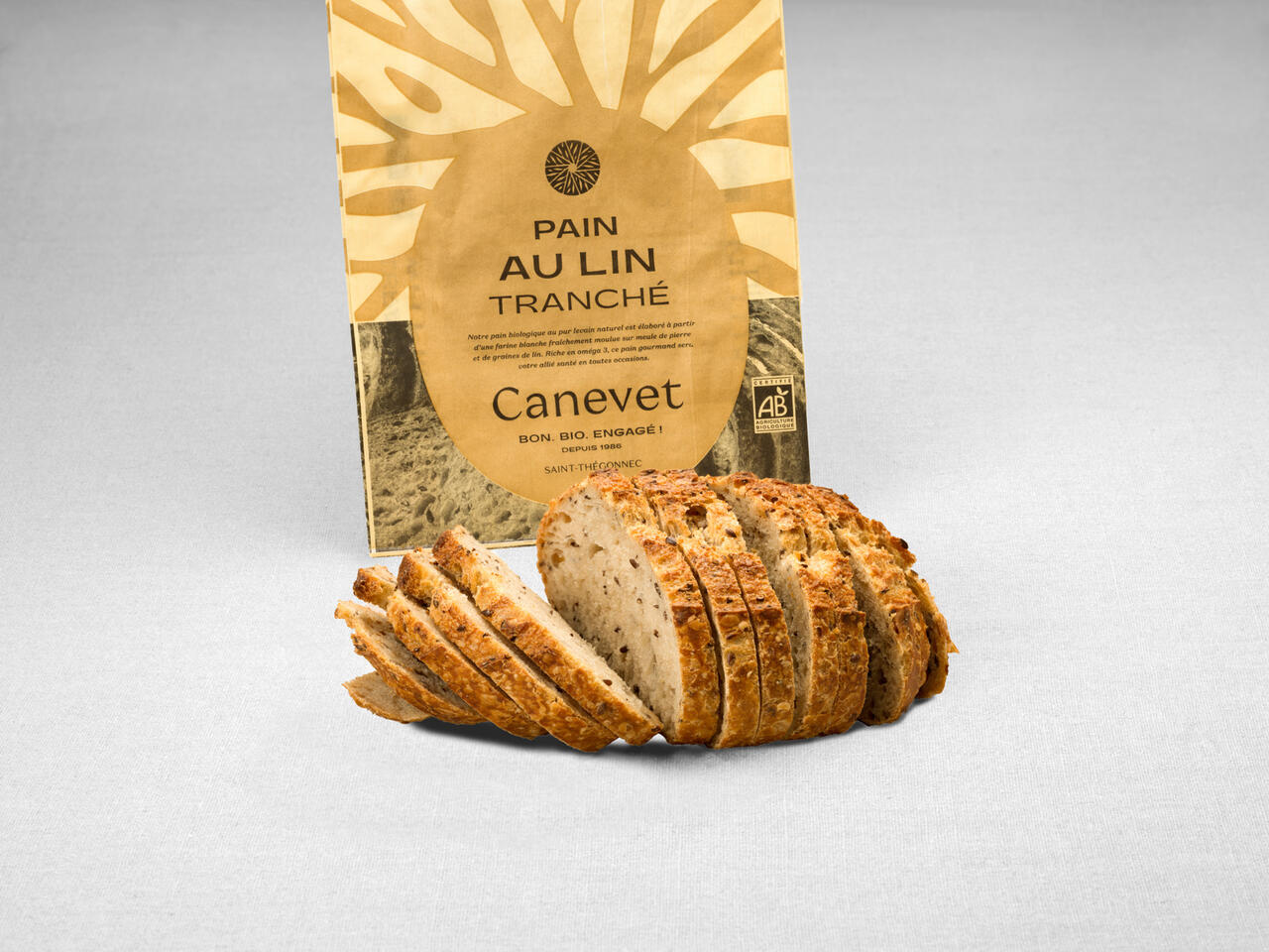 Pain aux graines de lin  au pur levain naturel tranché avec packaging en arrière plan