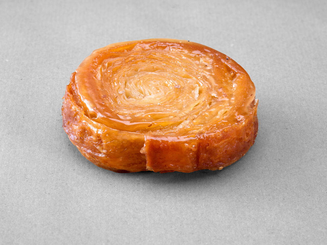 Petit kouign amann posé sur un fond gris