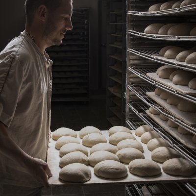 Un boulanger enfourne les pains bio Canevet, dans le fournil de Sant-Thegonnec