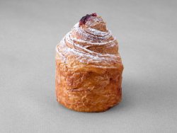 Cruffin aux myrtille posé sur un fond gris