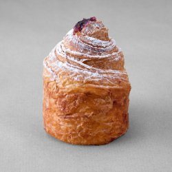 Cruffin aux myrtille posé sur un fond gris