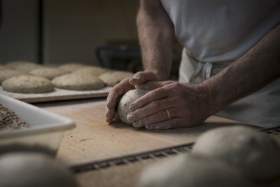 Un boulanger Canevet en train de mouler un pain